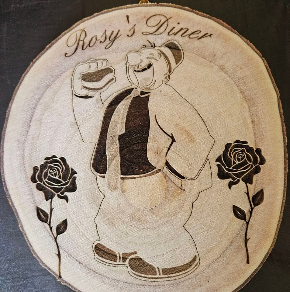Wood-burned Rosy's Diner artwork featuring a smiling diner holding a sandwich